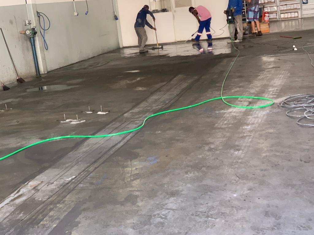 Preparação de concreto polido em área industrial antes do acabamento final
