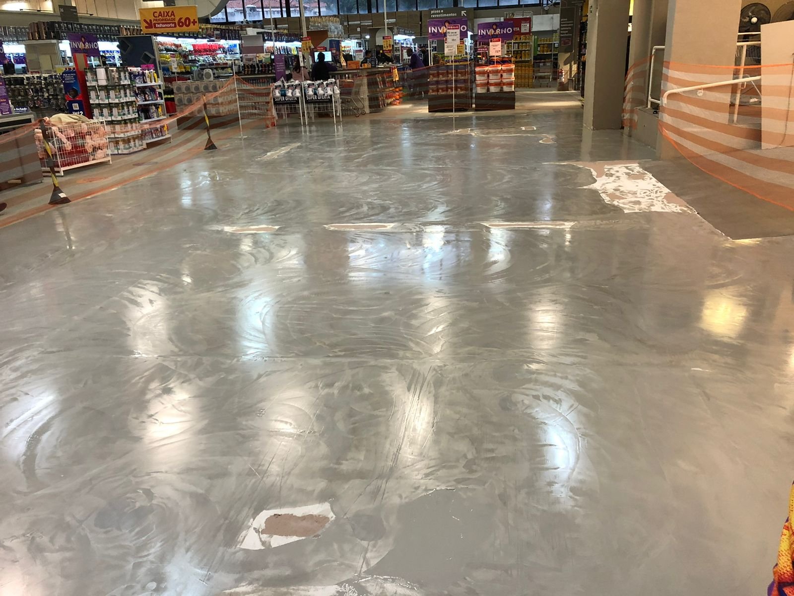 Piso industrial brilhante com faixas amarelas de demarcação em centro de distribuição