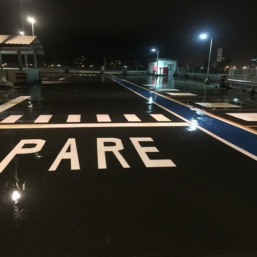 Estacionamento coberto com piso epóxi cinza e demarcação amarela de vagas e circulação