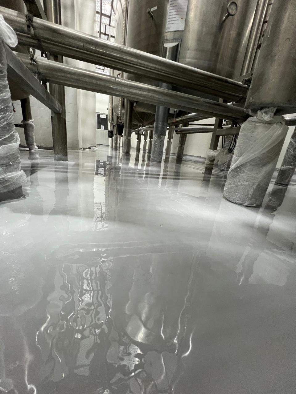 Piso industrial em área de produção alimentícia com revestimento resistente e lavável