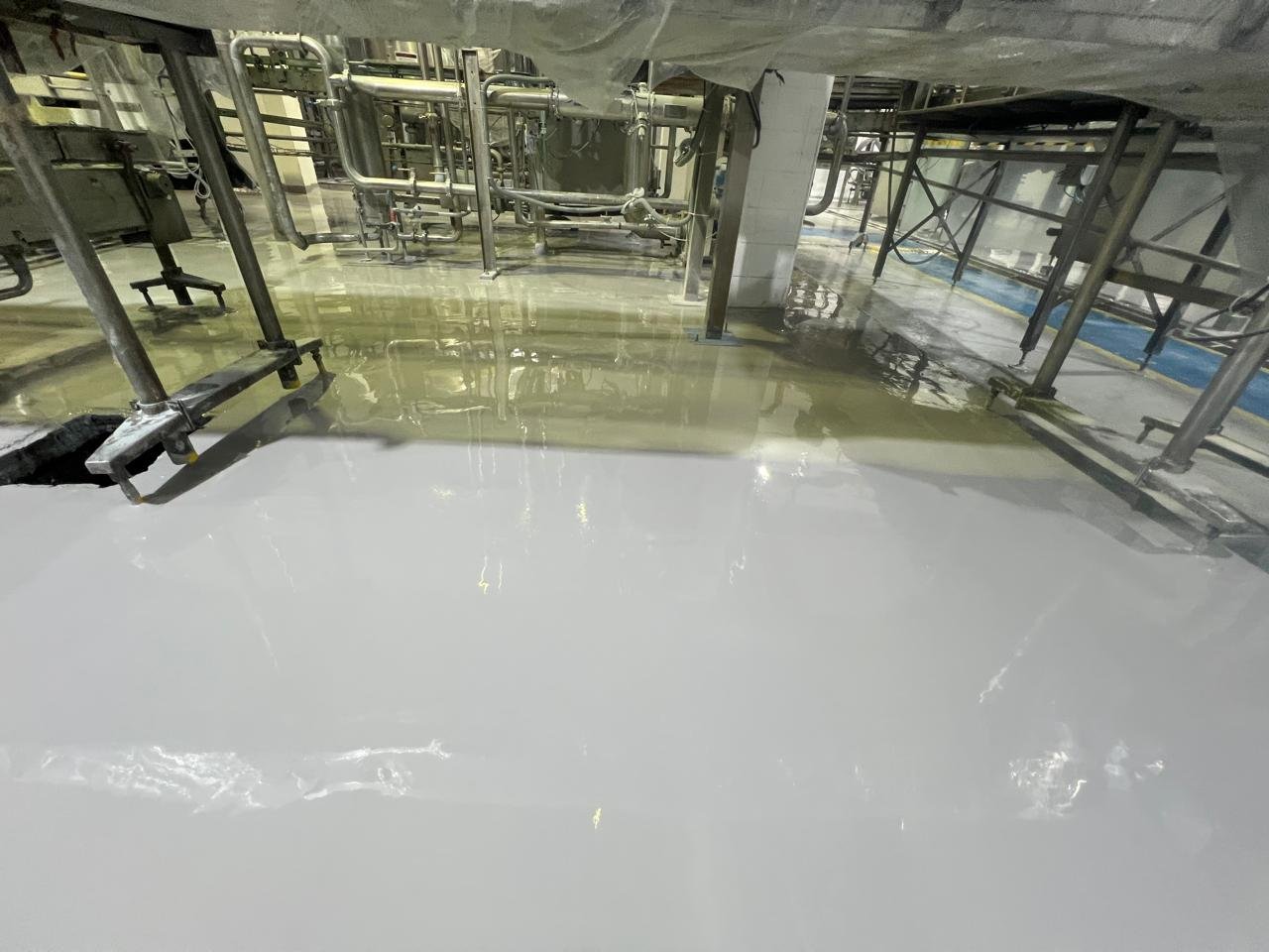 Piso industrial em área de produção alimentícia com revestimento resistente e lavável