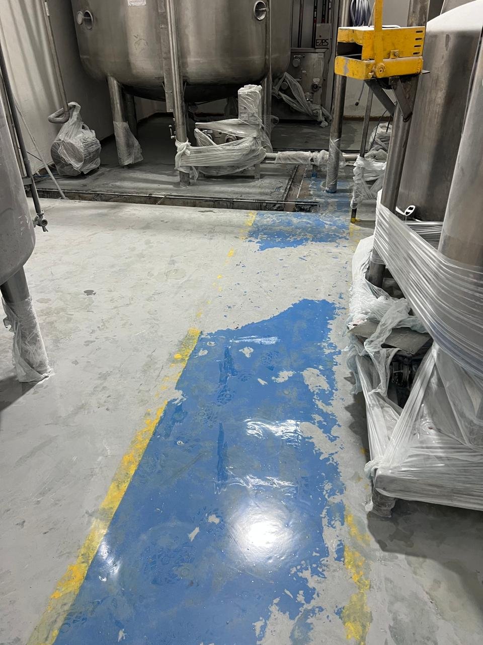 Preparação de concreto polido em área industrial antes do acabamento final