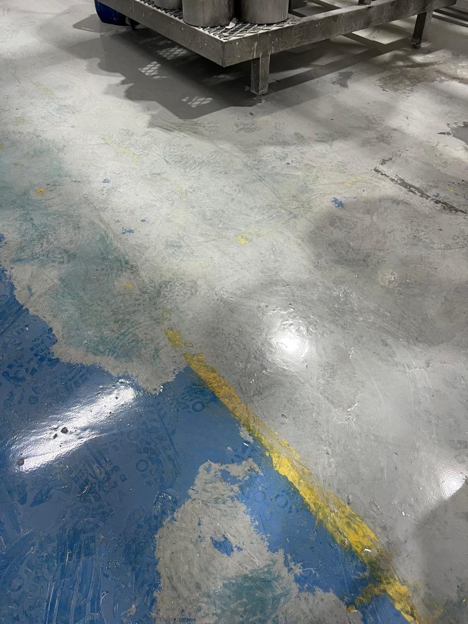 Piso industrial cinza com demarcação amarela em área logística de grande circulação